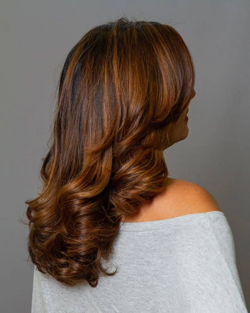 Cliente com morena iluminada finalizada na cadeira do IT Salão